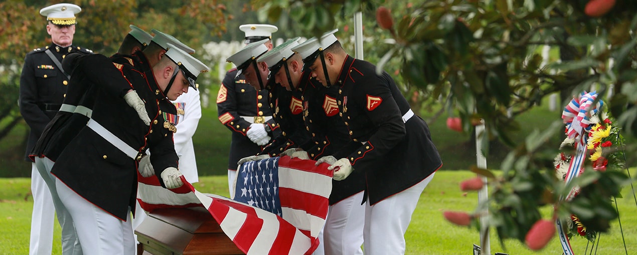 Marines folding flag at funeral ceremony